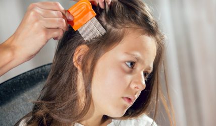 Mère qui vérifie la présence de poux de tête dans les cheveux de sa fille